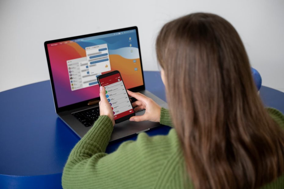 Mujer utilizando celular y computadora al mismo tiempo - Usabilidad web